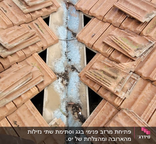 רעפים שבורים על גג עם תעלה מתכתית
